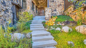 A stone building with a stone staircase leading to a wooden door. - Gorgeous Mountain Residence, Spectacular Views, Fire Pit (Vail)