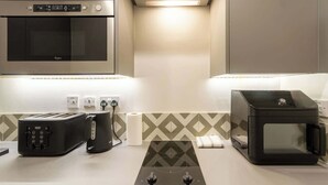 Una kitchenette equipada con horno empotrado, microondas, tostadora y cocina a gas.
