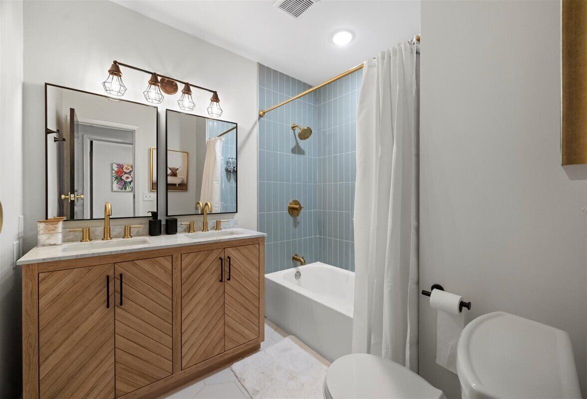 A modern bathroom with a wooden vanity, a large mirror, a bathtub, and a shower.