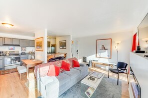 A modern apartment with a living room, kitchen, and dining area.