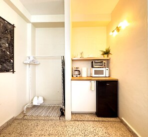 Una cocina compacta equipada con microondas, tostadora y cafetera.