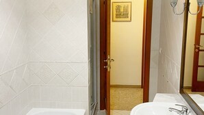 A bathroom with a bathtub, a sink, and a shower.
