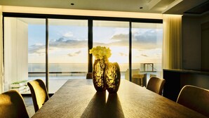 A modern dining room with a large table, chairs, and a vase of flowers. - Vila Cales e Chadas by Your Madeira Rentals (Arco da Calheta)