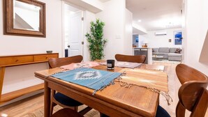 A dining area with a wooden table, chairs, and a large mirror on the wall. - Sojourn in DuPont Circle: Modern Meets Historic (Washington)