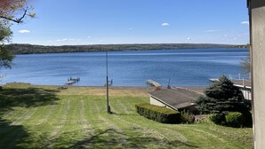 A lakeside view from a house with a dock and a small shed. - Spacious multi-level lakeside home w/ renovated kitchen and abundant parking!  (Penn Yan)
