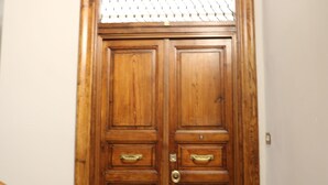 Une porte à deux battants en bois, dotée de poignées en laiton et d’un trou de serrure.