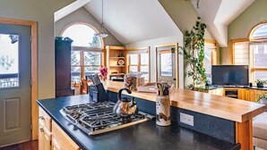 A modern kitchen with a central island, built-in appliances, and a large window. - The Kebler Home: Walk to Elk Ave! Dog Friendly! (Crested Butte)