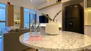 A modern living room with a marble table, a sofa, and a refrigerator.