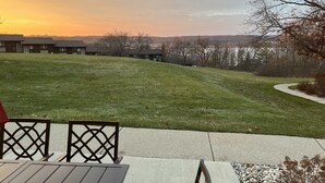 Eine Terrasse mit Blick auf eine Rasenfläche, einen Weg und eine Reihe von Gebäuden im Hintergrund.