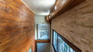 A narrow hallway with wooden walls and a brick wall on one side. A sign with the text "Berg Paradiso" is visible.