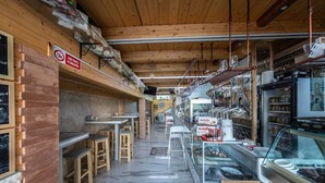 A restaurant with wooden interior, tables, and chairs.