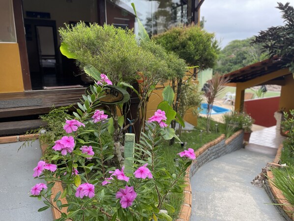 A pathway leading to a building with a sign reading "SAO". - Pousada Alto da Praia  (Porto Seguro)