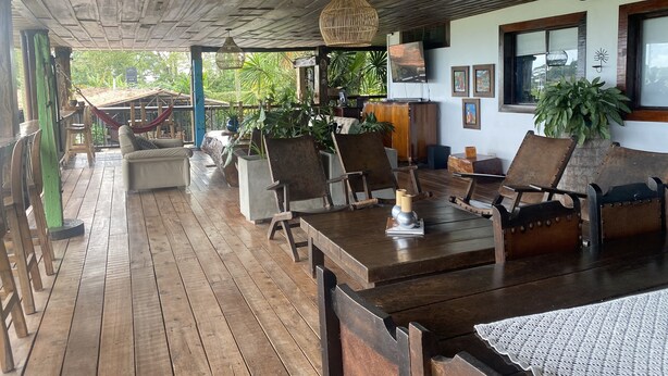 A wooden deck with outdoor seating, a hanging light fixture, and a TV mounted on the wall. - CASA HOTEL MÁLAGA (Montenegro)