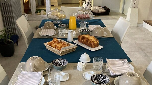 A breakfast setting with a variety of dishes, including fruit salad, pastries, and a Dalmatian dog. - La Maison de Triboulet, Chambres et Table D'hôtes, Extingo, Extingo (Pocé-sur-Cisse)