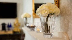 Un vase blanc orné de fleurs blanches, posé sur une étagère.