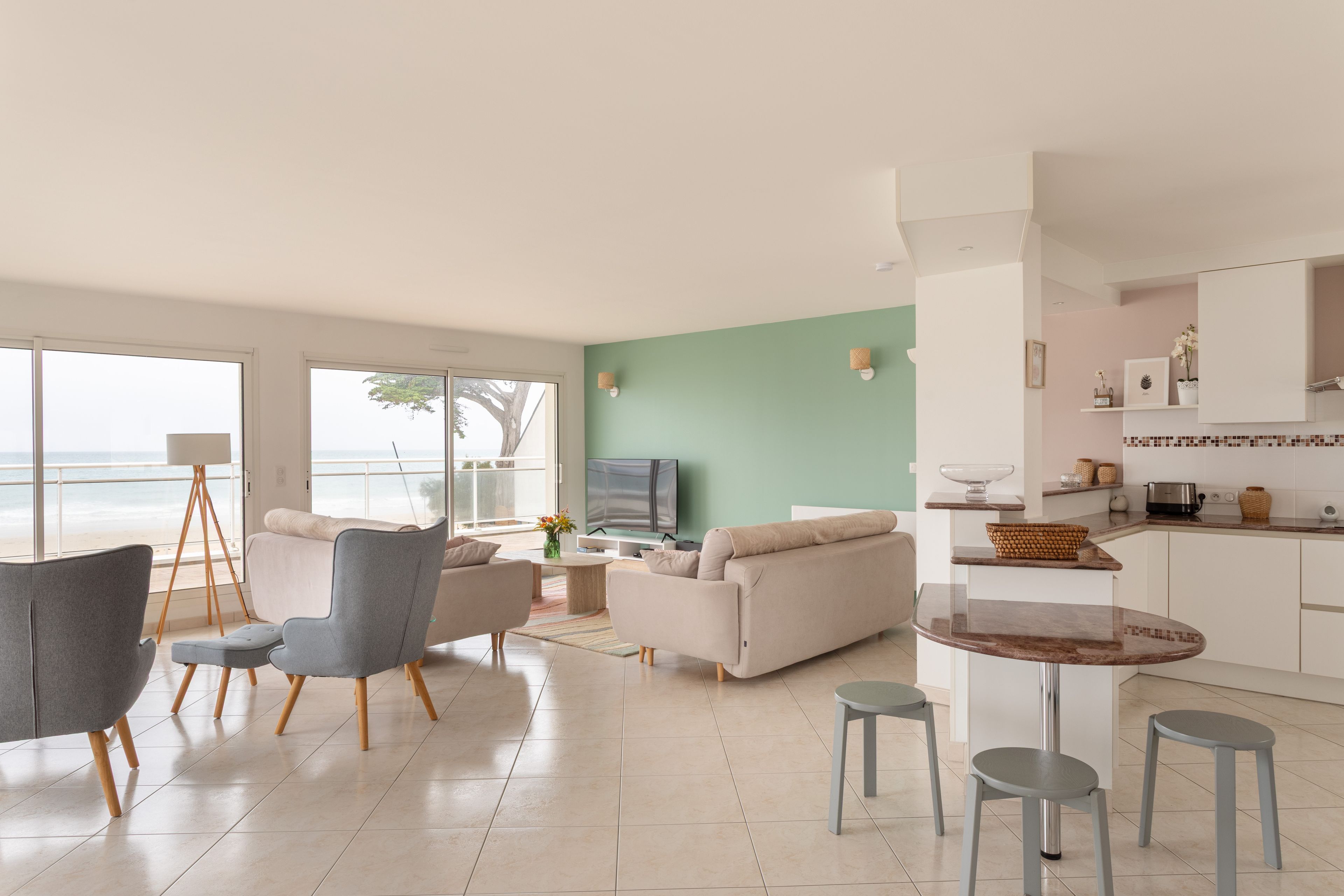 A modern living room with a sofa, chairs, a coffee table, and a TV.