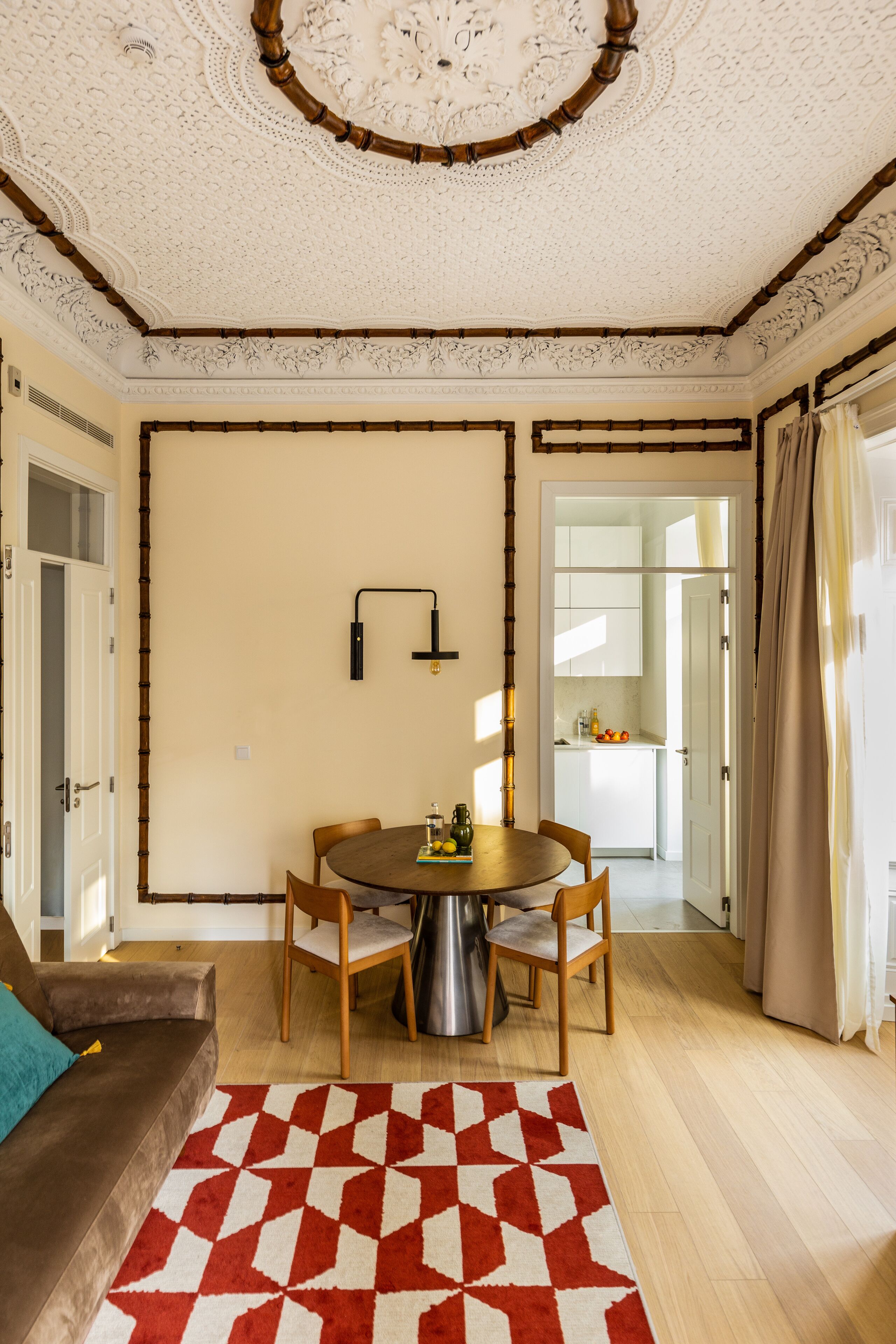 Un espace repas comprenant une table ronde, des chaises et un tapis à motifs.