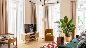 Una sala de estar moderna con televisor, sofá y comedor.