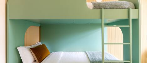 A bunk bed with a ladder, white bedding, and a brown pillow.