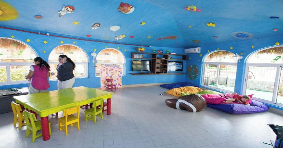 A room with a large table, chairs, a bean bag, and a window.