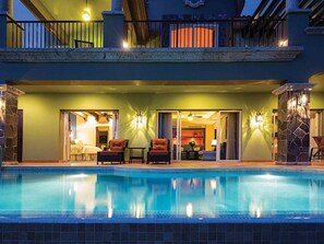 Une piscine dotée d’un espace couvert, d’un coin salon extérieur et d’un balcon.