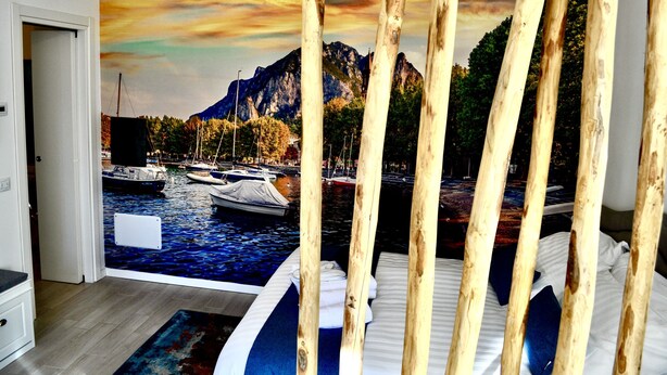 Un dormitori amb un mural que representa un port esportiu i muntanyes.