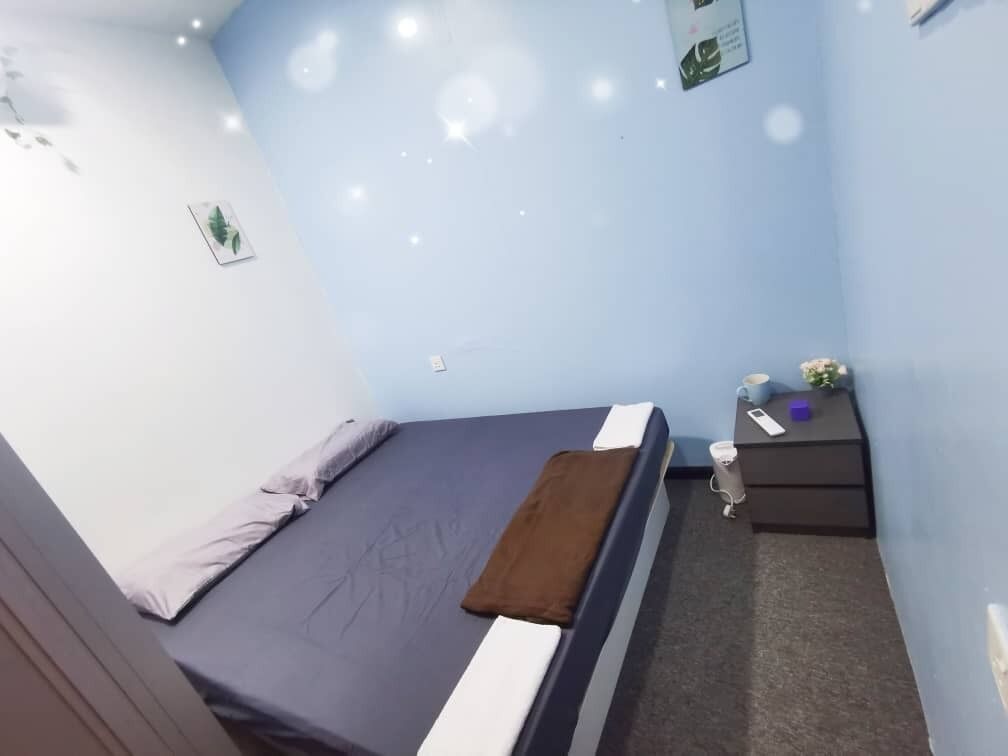 Ein Zimmer mit einem Bett, einem Nachttisch und einem kleinen Beistelltisch.
