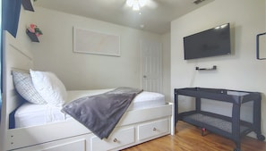 A bedroom with a bed, a TV, a door, and a wall-mounted shelf. - Private Entry Studio w/ Kitchenette, 15mi Disney (Davenport)