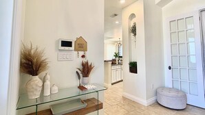 A modern kitchen with white cabinets, a glass countertop, and a hanging plant. - New Vista | Chef Kitchen, Golf Course Views (San Antonio)