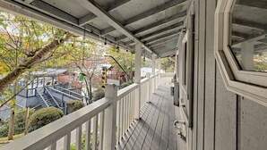 A covered porch with a railing, a staircase, and a view of the surrounding area. - T Landing Top & Bottom Units (Clayton)