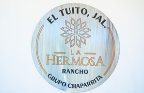 A circular sign with the text "EL TUITO, JAL. LA HERMOSA RANCHO GRUPO CHAPARRITA".