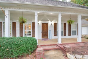 A white house with a porch, a front door, and a mailbox.