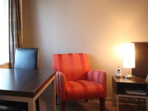A hotel room with a wooden table, a striped armchair, a lamp, and a small side table. - 388 on Tay Motel  (Invercargill)