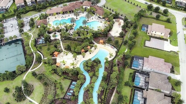 An aerial view of a resort with multiple swimming pools, a winding water feature, and surrounding greenery. - ⭐⭐⭐⭐⭐Spacious 10-BR Family Retreat Near Disney, Solterra Resort - Pool Spa, Game (Davenport)