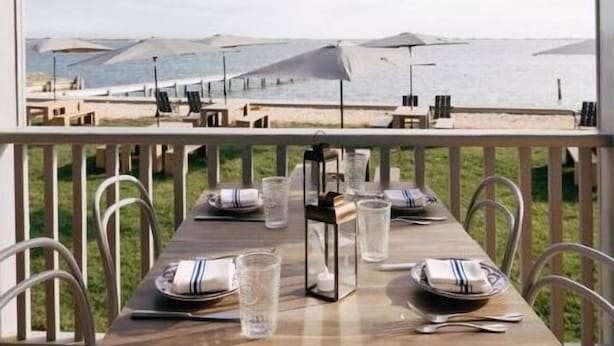 Mesa para dos personas con vista al mar y a las montañas.