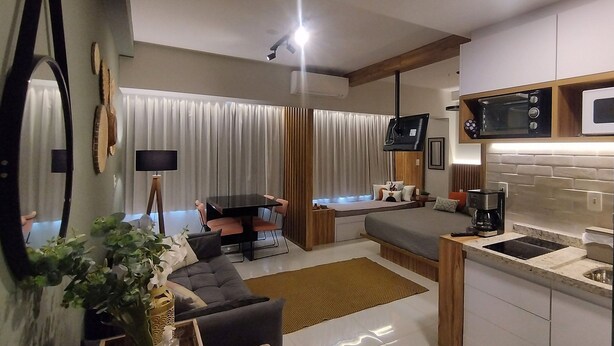 A modern apartment with a living room, dining area, kitchenette, and a small bedroom. - Living (Poços de Caldas)