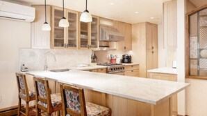 A kitchen with a large island, wooden cabinets, and pendant lighting. - North Of Nell, Unit 4b (Aspen)