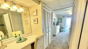 A bedroom with a large bed, a dresser, a mirror, and a radiator. - Ponce Inlet 6th Floor Ocean View Corner Unit- 2bdrm 2bath- Non Drive Beach  (Ponce Inlet)