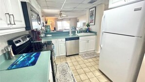 A kitchen with white cabinets, a stainless steel refrigerator, and a blue countertop. - Ponce Inlet 6th Floor Ocean View Corner Unit- 2bdrm 2bath- Non Drive Beach  (Ponce Inlet)