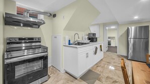 A modern kitchen with a built-in oven, a stainless steel range hood, and a refrigerator. - Spacious 2 Bedroom Guest Suite in North York (Toronto)