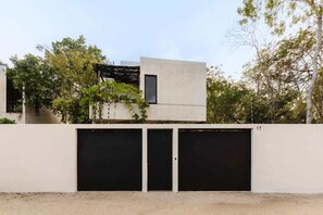 A modern building with a flat roof, a small window, and a garage with two doors.