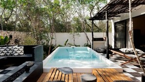 A swimming pool with lounge chairs and a stone wall.