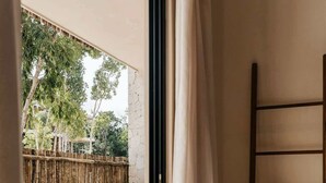 A bedroom with a large window, a bed, a wooden ladder, and a small pool. - Casa Coba Plunge Pool Beach Club Aldea Zama (Tulum)