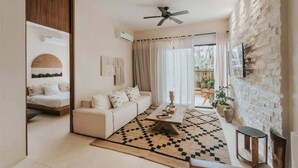 A modern living room with a sofa, coffee table, and a patterned rug. - Casa Coba Plunge Pool Beach Club Aldea Zama (Tulum)