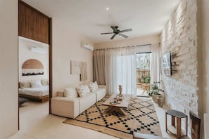 A modern living room with a sofa, coffee table, and a patterned rug. - Casa Coba Plunge Pool Beach Club Aldea Zama (Tulum)