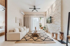 Un salon moderne avec un canapé, une table basse et un tapis à motifs.
