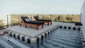 A rooftop pool with two lounge chairs and a clear view of the surrounding landscape. - Jungle Modern Loft 101 Aldea Zama Walk Everywhere (Tulum)