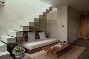 Un salon moderne avec un canapé, une table basse et un escalier au design original.