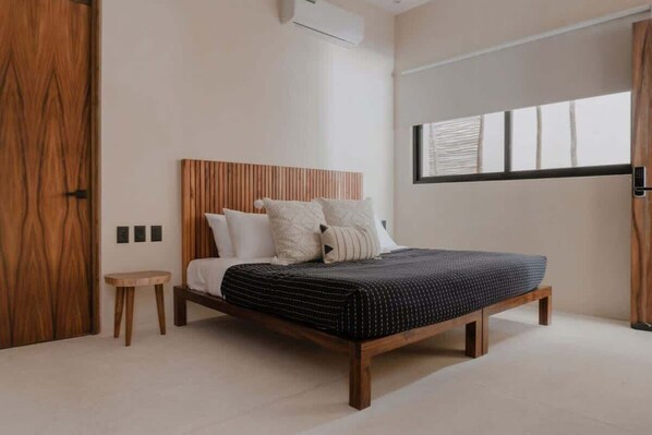Ein modernes Schlafzimmer mit einem hölzernen Bett, einem kleinen Nachttisch und einem Fenster mit Jalousien.