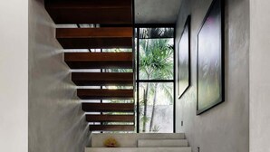 A staircase with a concrete finish, wooden slats, and a woven basket at the bottom. - Casa Iguana Private Villa Large Pool Beach Club (Tulum)